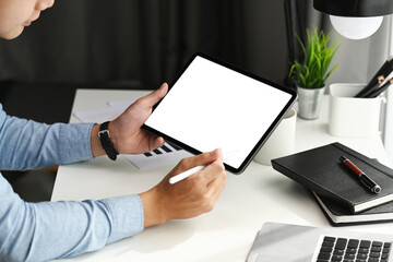 Cropped shot of graphic designer using stylus pen pointing on tablet. Blank screen for product...