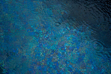 Fototapeta na wymiar Circle water ripple wave surface background. Rain drop on swimming pool, blue background