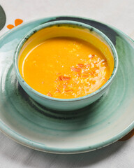 Pumpkin soup with fresh pumpkin seeds served in a bowl over traditional Ukrainian tablecloth. Ukrainian cuisine concept.
