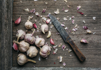 The process of cleaning garlic. Garlic and leaves on wooden background.