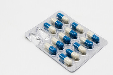 Tablets-capsules in a blister close-up, two cells are empty.