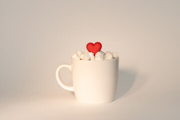 A cup of coffee or tea or cocoa with marshmallows. Heart shaped marshmallow in a cup with a hot drink made with love. Valentine’s or wedding Day, Merry Christmas concept