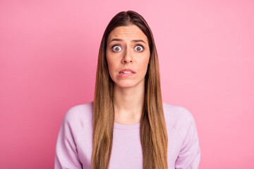 Fototapeta premium Close-up portrait of lovely confused scared straight-haired girl biting lips panic isolated over pink pastel color background