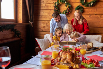 grandmother spending time with children and grandchildren, reading book, talking, spare time together on the eve of christmas, at home