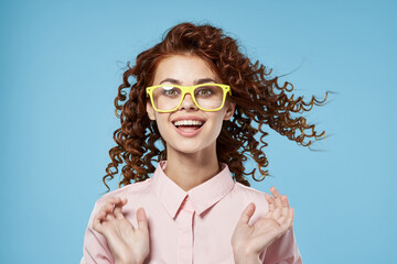 Woman with curly hair and yellow pink shirt blue background 