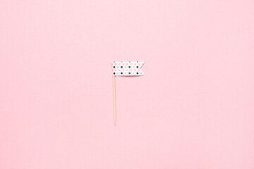 Festive background made of decorative flag . Pink trend background with little flags on it. Flat lay style.