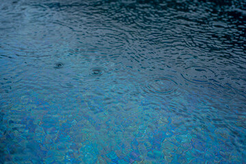 Circle water ripple wave surface background. Rain drop on swimming pool, blue background. High quality photo