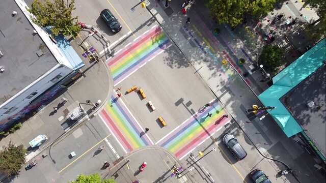 2-3 aerial twist panaramic birds eye view above Davie and Bute rainbow sidewalks in downtown Vancouver's Gay Village Coimmunity on sunny afternoon with COVID-19 barriers on streets with light traffic