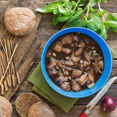 Cooking burgers with vegetables and meat on a wooden table, top view