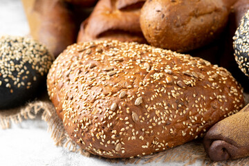 Rye bread. Rye bread of different shapes on a light gray table. Baguettes, loaves, round bread and rolls on the table