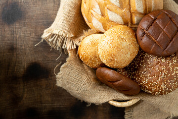 Wheat and rye bread. Rye and wheat bread of different shapes on a light gray table. Round wheat bread, buns and Burger buns on the table. The view from the top. Copyspace
