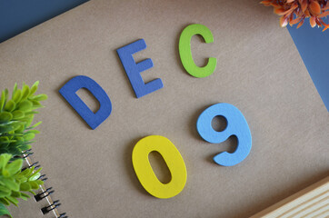 December 9, Cover design in natural concept with a brown notebook and colorful wooden alphabet.