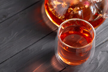 Glass tea cup and teapot on table