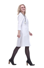 in full growth. smiling woman doctor striding confidently forward.