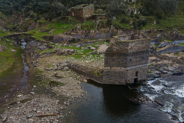 Fototapeta na wymiar Mill tower and other ancient ruins on the bank of the Alagon River. Casillas de Coria. S