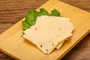 Sliced yellow cheese over board