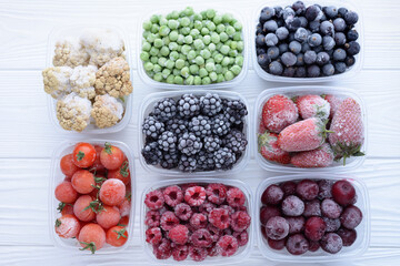 Frozen berries in boxes top view on white background