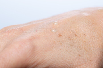 Water drops on woman hand skin, close up of wet human skin texture
