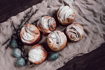 Traditional cupcake Easter cake kraffin with raisins on dark wooden background. homemade cake Cruffin with candied fruits. Naturally Eggs painted with hibiscus with marble stone effect.