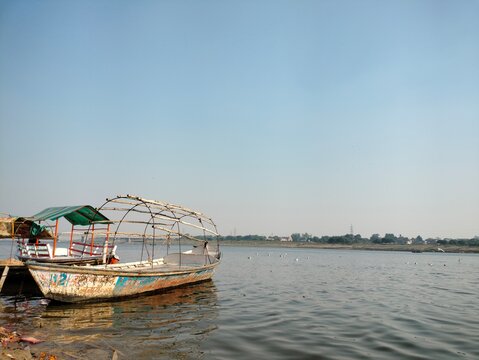 Prayagraj, Uttar Pradesh India- November 21 2020: Old wooden boats are floating near the shore of the holy river- Ganges.