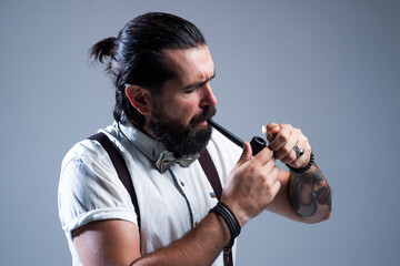 brutal mature man smoking pipe in bow tie, male lifestyle