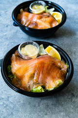 Take Away Salmon Gravlax Salad in Black Plastic Bowl Container and Mustard Sauce Package.