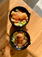 Take Away Salmon Gravlax Salad in Black Plastic Bowl Container and Mustard Sauce Package.