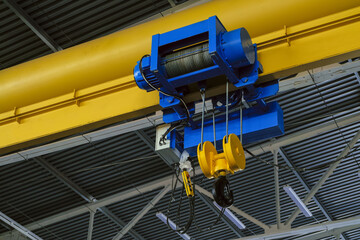 Overhead traveling cathead with steel hooks in industrial engeenering plant shop. Steel slings.