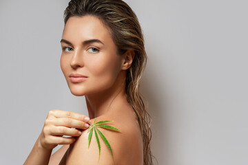 CBD cosmetics concept. Beautiful woman with a cannabis leaf