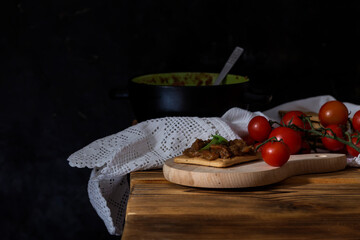 Stewed eggplant caviar in a bowl and cherry tomatoes close-up
