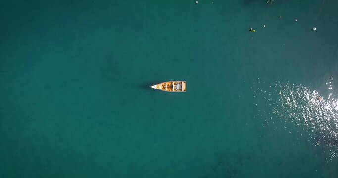 Bird eye view of a small fishing boat floating in a calm Caribbean Sea Marina