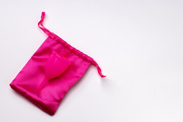 Pink silicone menstrual cup on white background