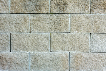 A grey wall made out of decorative concrete blocks.