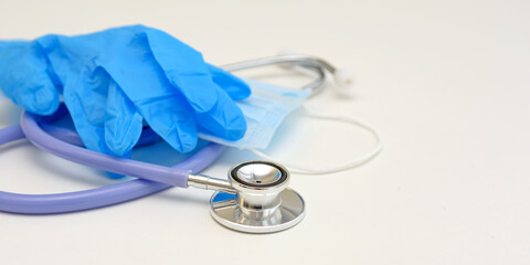 Stethoscope, medical mask and gloves on a white background. Close up.