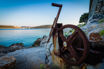 Old rusty winch positioned on the steep coast for wheeling boats in and out of water.