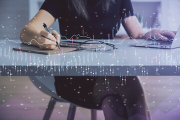 Double exposure of businesswoman hands typing on computer and forex chart hologram drawing. Financial analysis concept.