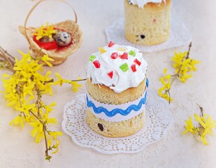 Traditional Easter cake decorated with sugar fondant and multi-colored candied fruits on a light concrete background. Easter concept. Festive Easter baking recipes.