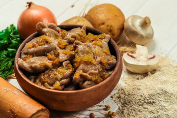 Traditional east european dumplings (vareniks) with fried onion in ceramic bowl. Ukrainian varenyki and ingridients on the kitchen table. Slavic food concept