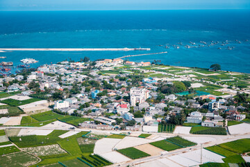 high view from Thoi Loi Mountain, fishing village and garlic fields at Ly Son island, Quang Ngai Province, Viet Nam