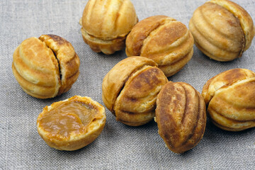 Homemade cookies nuts with condensed milk. Homemade shortbread nuts. Delicious cookies. Homemade cookies stuffed with boiled condensed milk on a gray tablecloth.