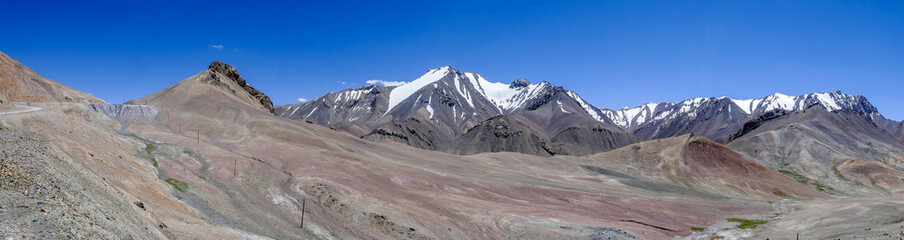 Fototapeta premium Panoramic view with pastel colors of mountains along high altitude Pamir Highway at Ak Baital pass, Murghab district, Gorno-Badakshan, Tajikistan