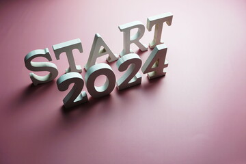 Start 2024 alphabet letter on pink background