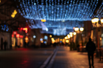 Blurred image of night european city in christmas illumination, urban background and texture