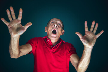 Pushing away from. Portrait of crazy scared and shocked caucasian man isolated on dark background....