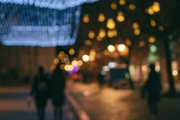 Blurred image of night european city in christmas illumination, urban background and texture