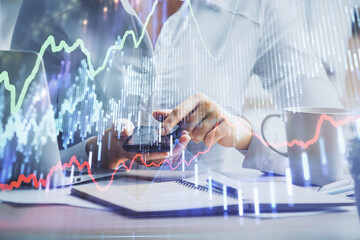 Double exposure of forex chart sketch hologram and woman holding and using a mobile device. Financial market concept.