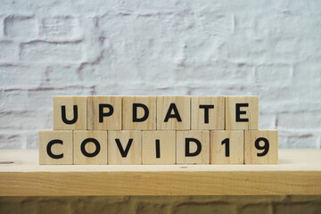 Update Covid-19 alphabet letter on white brick wall background