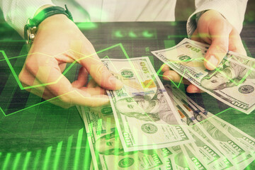 Multi exposure of financial graph drawing hologram and USA dollars bills and man hands. Analysis concept.