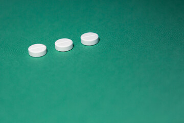 close up. three tablets on a green background.