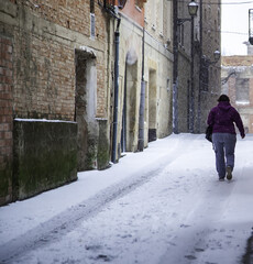 Fototapeta na wymiar Person walking street with snow